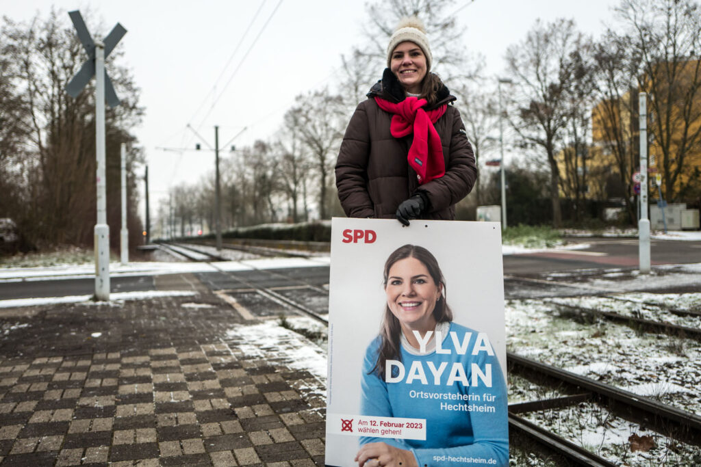 Foto von Ylva Dayan mit einem ihrer Plakate, aufgenommen an der Kreuzung Dornsheimer Weg und Bürgermeister-Heinrich-Dreibus-Straße